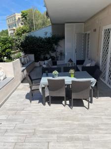 a patio with a table and chairs and a couch at Aria di Mare in Lido di Ostia