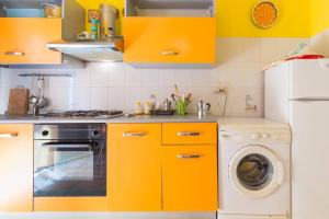 a kitchen with orange cabinets and a washing machine at Estrellas De Mar Casa in Giardini Naxos +5 photos