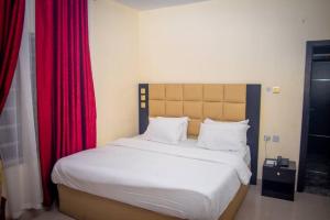 a bedroom with a large bed with red curtains at Diamond castle Hotel in Mama