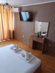 a bedroom with a bed and a vanity and a mirror at Къща за гости Смокиня in Obzor