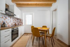 małą kuchnię z drewnianym stołem i krzesłami w obiekcie Premium Apartment MiDa Vrsar w mieście Vrsar
