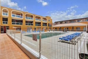 un edificio con piscina y sillas azules en Casa Bita El Cotillo Playa home with swimming pool, en Cotillo