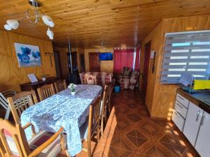 a dining room with a table and a kitchen at La Casita del Campo in Conguillío