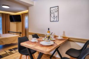 a room with a table and chairs and a bed at Gailas Luxury Apartments in Mantoúkion