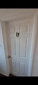 a white door with two black cats on it at Rachel's house in Manchester