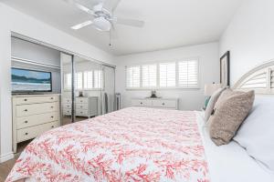 a white bedroom with a bed and a tv at 3Br Coastal Home W Large Oceanview Patio Steps To Sand By Beachview Rentals in Newport Beach