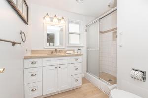 a white bathroom with a sink and a shower at 3Br Coastal Home W Large Oceanview Patio Steps To Sand By Beachview Rentals in Newport Beach +21 photos