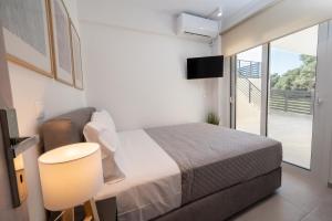 a bedroom with a bed and a sliding glass door at Rastoni Luxury Home in Pogoniá +34 photos