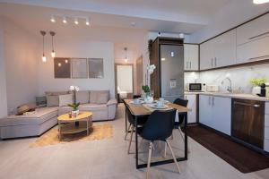 a kitchen and living room with a table and a couch at Rastoni Luxury Home in Pogoniá