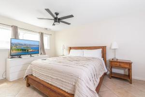 a bedroom with a bed and a flat screen tv at Pet-Friendly 3Br Retreat One House From The Sand By Beachview Rentals in Newport Beach