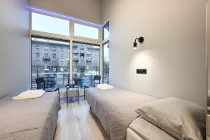 two beds in a room with a large window at Nomad Boutique Hostel - Women Only, Self Check-In, City Centre in Tallinn
