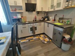 una cucina con mobili bianchi e un piano di lavoro di къща Горски чар a Beli Osam