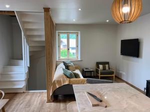 a living room with a couch and a staircase at Chalet Tomsine in Samoëns