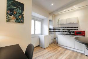 a kitchen with white cabinets and a table and a window at Beautiful bright apartment - Near Fourvière in Lyon