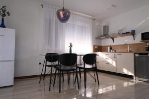 a kitchen with a table and chairs in a room at Seaside Serenity "Sea" with pool, 150m from sea in Sukošan +21 photos