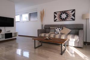 a living room with a couch and a coffee table at Seaside Serenity "Sea" with pool, 150m from sea in Sukošan