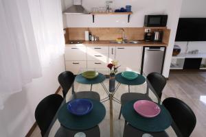 a table and chairs with plates on it in a kitchen at Seaside Serenity "Sea" with pool, 150m from sea in Sukošan