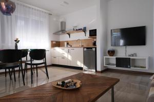 a living room with a table and a kitchen at Seaside Serenity "Sea" with pool, 150m from sea in Sukošan