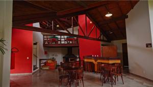 a dining room with red walls and wooden tables and chairs at Hotel Villa Passaredo in Tijucas do Sul