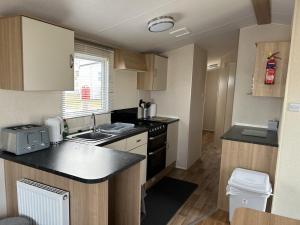 a small kitchen with a sink and a counter top at A13 - Beach Haven at Silversands in Lossiemouth