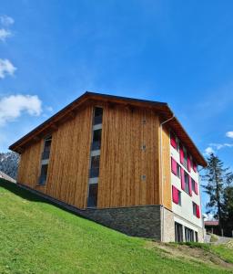 a building on top of a grassy hill at Chesa Bunita Trais in Gaschurn