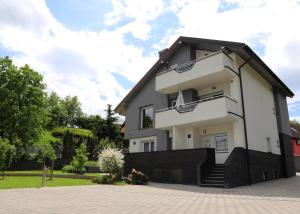 a white house with a black roof at Dalma Pro Apartments - Cozy Studio & Spacious One-Bedroom Apartment - Self Check-in in Karlovac