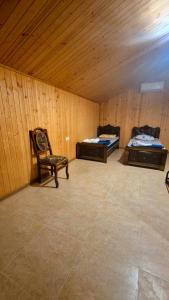 a room with two beds and a chair in it at kotej lazi in Itʼkhvisi