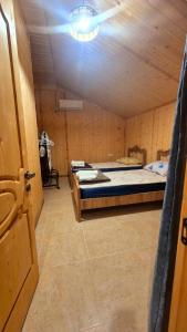 a room with two beds in a wooden room at kotej lazi in Itʼkhvisi