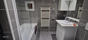 a bathroom with a shower tub and a sink at Cosy blyes in Blyes