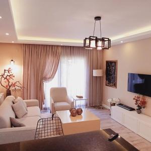 a living room with a couch and a tv at Metropolitan Art in Altınkum