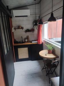 a small kitchen with a table and a table and chairs at La cabane zen in Saint-Martin-des-Champs
