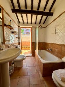 y baño con 2 aseos, bañera y lavamanos. en Villa Tana Pacenzia, en Cefalú
