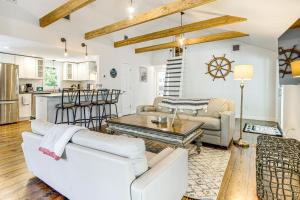 a living room with white furniture and a kitchen at 4 Mi to Beach Cape Cod Retreat in Mashpee! in Mashpee