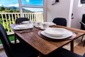 a wooden table with white plates and cups on it at Villajesu Apartamento in Villeta