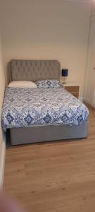 a bedroom with a bed with a blue comforter at Lovely 2 Bed Garden Level Apartment Blackrock in Blackrock