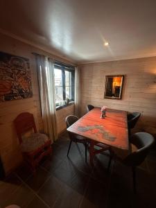 una sala da pranzo con tavolo e sedie in legno di Ski in-ski out leilighet Hemsedal a Fausko