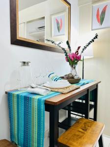 a table with a table cloth and a vase of flowers at Affordable Condo Near SM Southmall in Manila