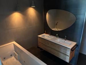 a bathroom with a tub and a sink and a mirror at B & B Huize Hertog met Whirlpool in Apeldoorn +29 photos