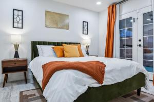 una camera da letto con un letto grande con cuscini arancioni e bianchi di Havasu Fun Stay Pool Spa PoolTable KingBed a Lake Havasu City Altre 37 foto