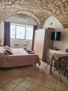 萨萨里Mulino 1的一间带床、桌子和电视的卧室