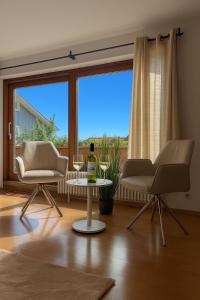 マルクドルフにあるSTAYS Gehrenberg am Bodenseeのリビングルーム(椅子2脚、テーブル付)、窓が備わります。