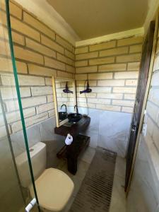 a bathroom with a toilet and a sink and a mirror at Chale Beija flor in Praia Grande