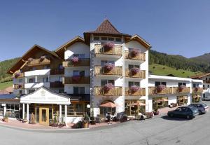 un grand bâtiment avec des voitures garées devant dans l'établissement Erlebnishotel Fendels, à Fendels