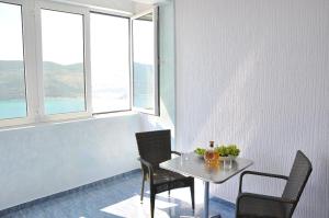 un tavolo con sedie in una stanza con finestre di Apartment Bayer a Herceg-Novi