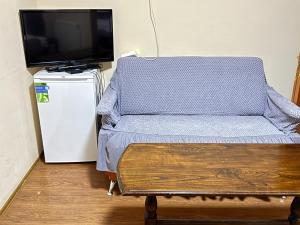 a room with a couch and a tv and a table at Hotel Imereti - Old Tbilisi Center in Tbilisi City
