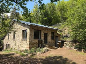 Le refuge d'Yzeron, gite autonome en pleine forêt pour 8 personnes في Yzeron: منزل حجري في وسط غابه