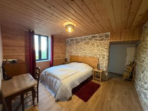 Le refuge d'Yzeron, gite autonome en pleine forêt pour 8 personnes في Yzeron: غرفة نوم بسرير وجدار حجري