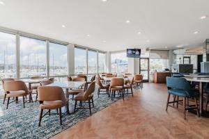Un restaurante con mesas y sillas y grandes ventanales. en Bay Club Hotel and Marina, en San Diego