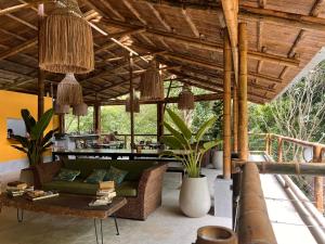 an outdoor living room with a green couch and chairs at Costeño River Minca in Minca