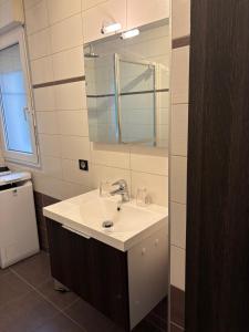 un baño con lavabo y espejo en Heart of Saint-Louis - Airport, station, borders, en Saint-Louis 12 fotos más